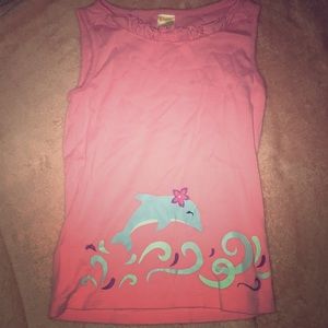 A pink shirt with a dolphin decoration in front.
